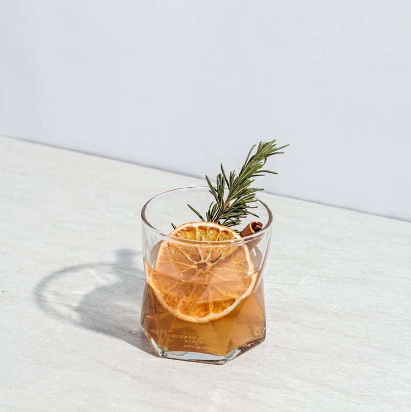 Cóctel old fashioned con naranja deshidratada y canela